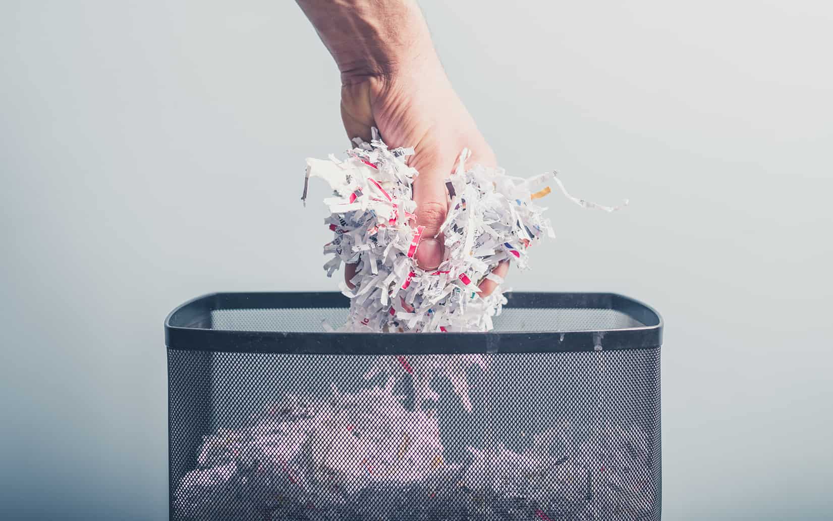 Hand Putting Shredded Paper In Basket